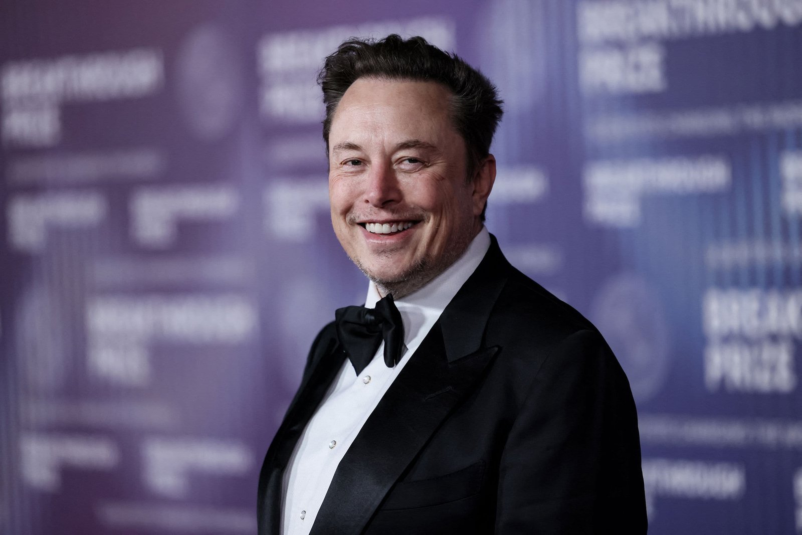 Portrait of Elon Musk smiling.